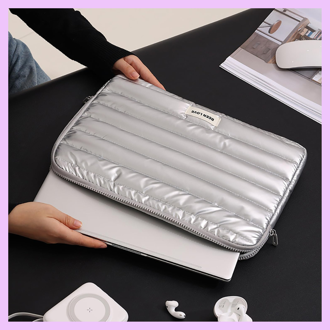 Silver puffer laptop sleeve protecting a 13-14 inch laptop with padded shock-absorbing design